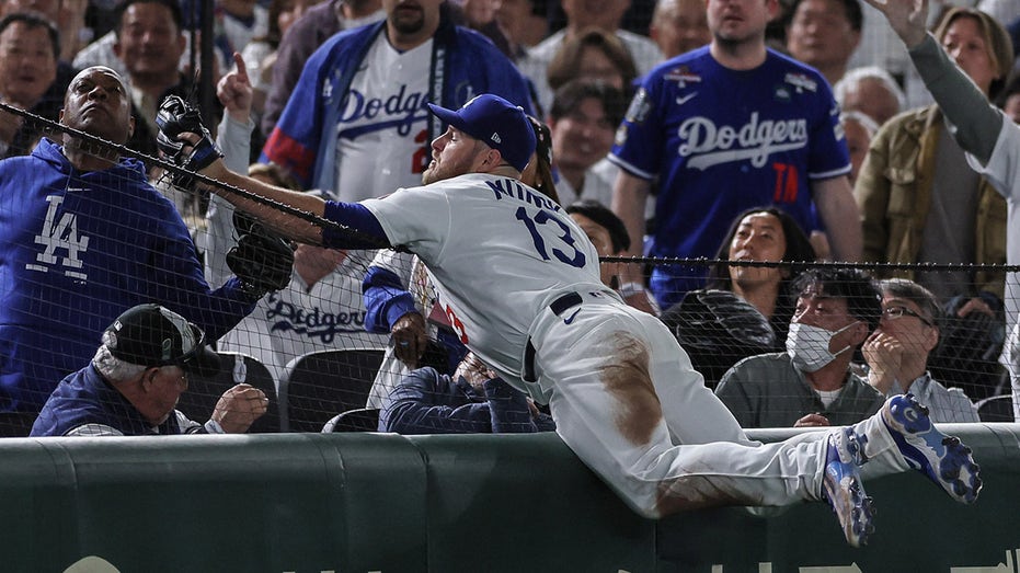 Dodgers' Max Muncy looks stunned as ex-NFL quarterback Rodney Peete snags foul ball from the stands